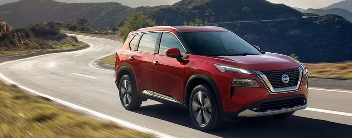 A red 2024 Nissan Rogue SL is shown driving to a Nissan dealer near Janesville.