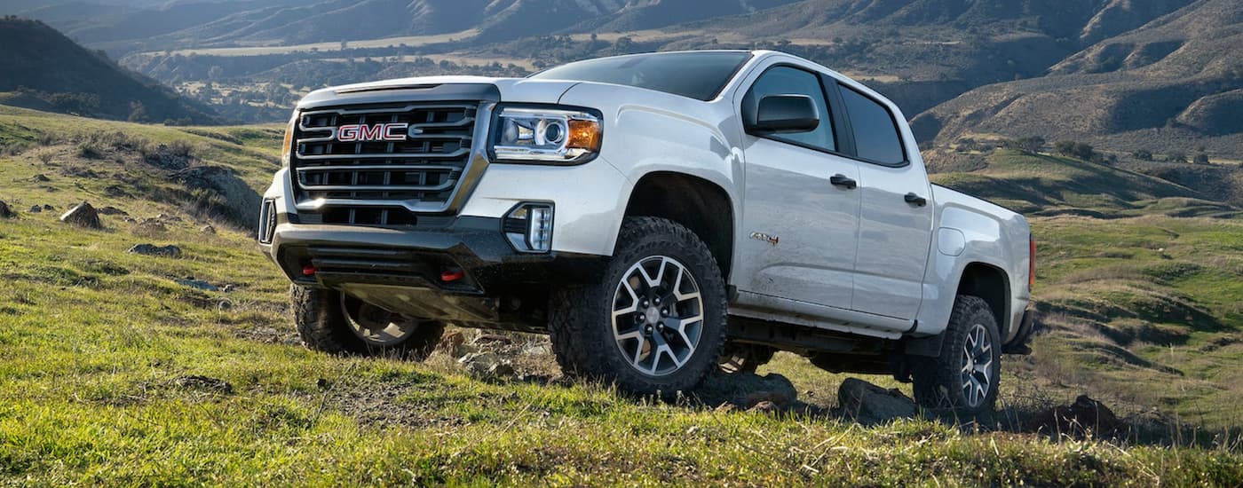 A white 2021 GMC Canyon AT4 is shown parked off-road.