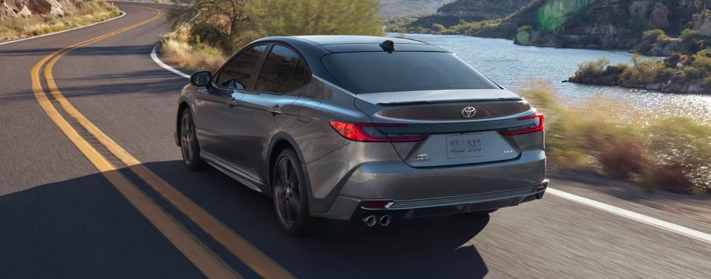 A grey 2025 Toyota Camry XSE driving near a river after leaving a Toyota dealer near you.