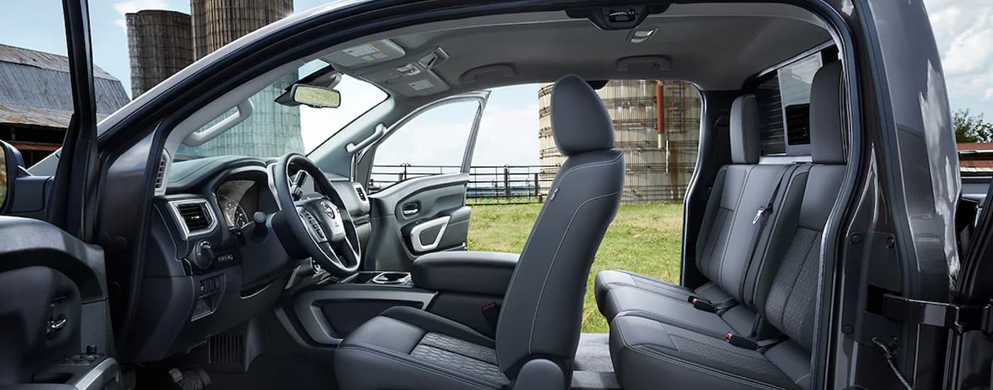 The grey interior of a 2024 Nissan Titan King Cab SV shows two rows of seating.