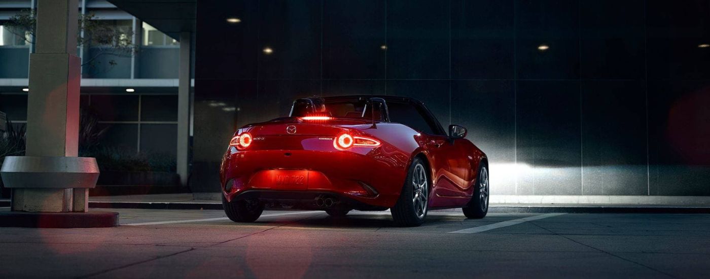 A red 2023 Mazda MX-5 Miata is shown at night after visiting a Mazda dealer near Mill Creek.