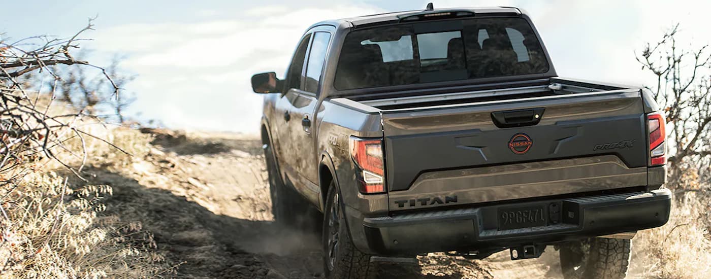 A brown 2024 Nissan Titan PRO-4X off-roading on a dusty path.