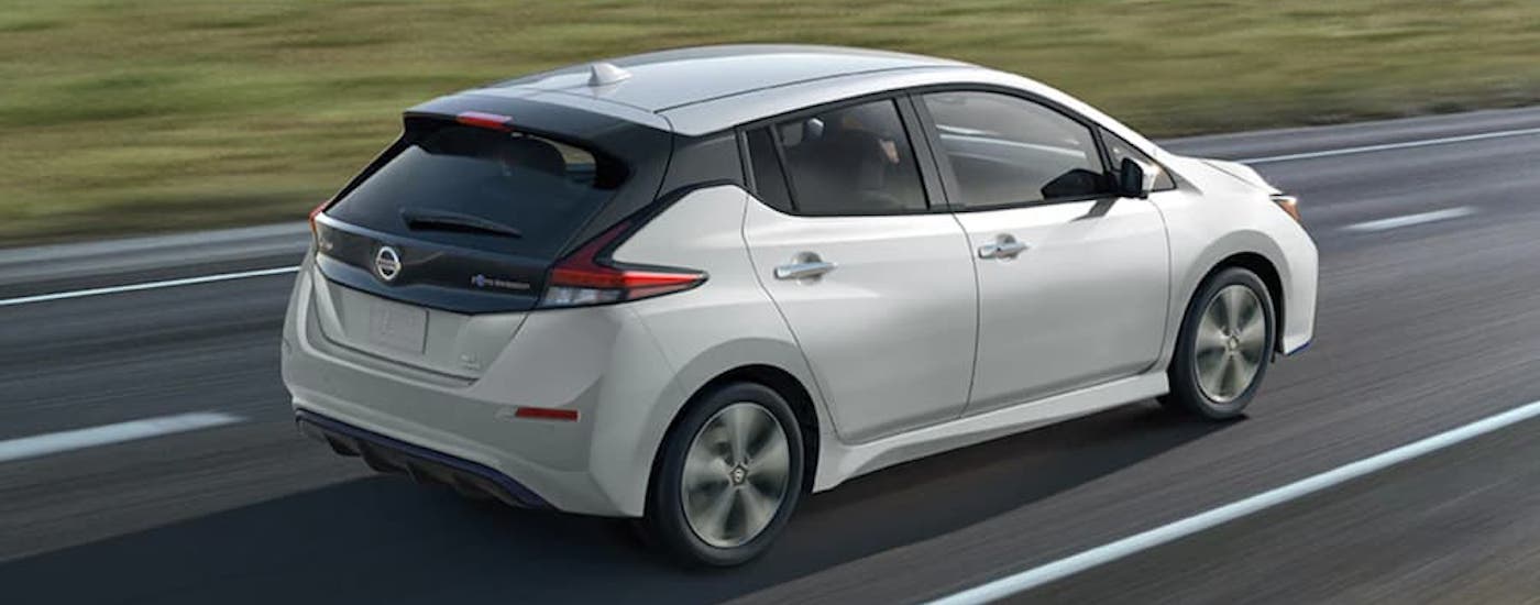 A white 2021 Nissan LEAF is shown from the rear at an angle.