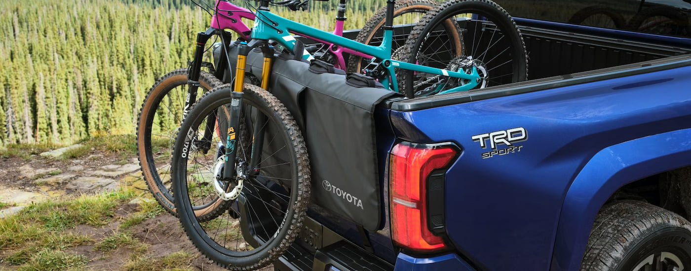 Mountain bikes in the back of a blue 2024 Toyota Tacoma TRD Sport for sale.
