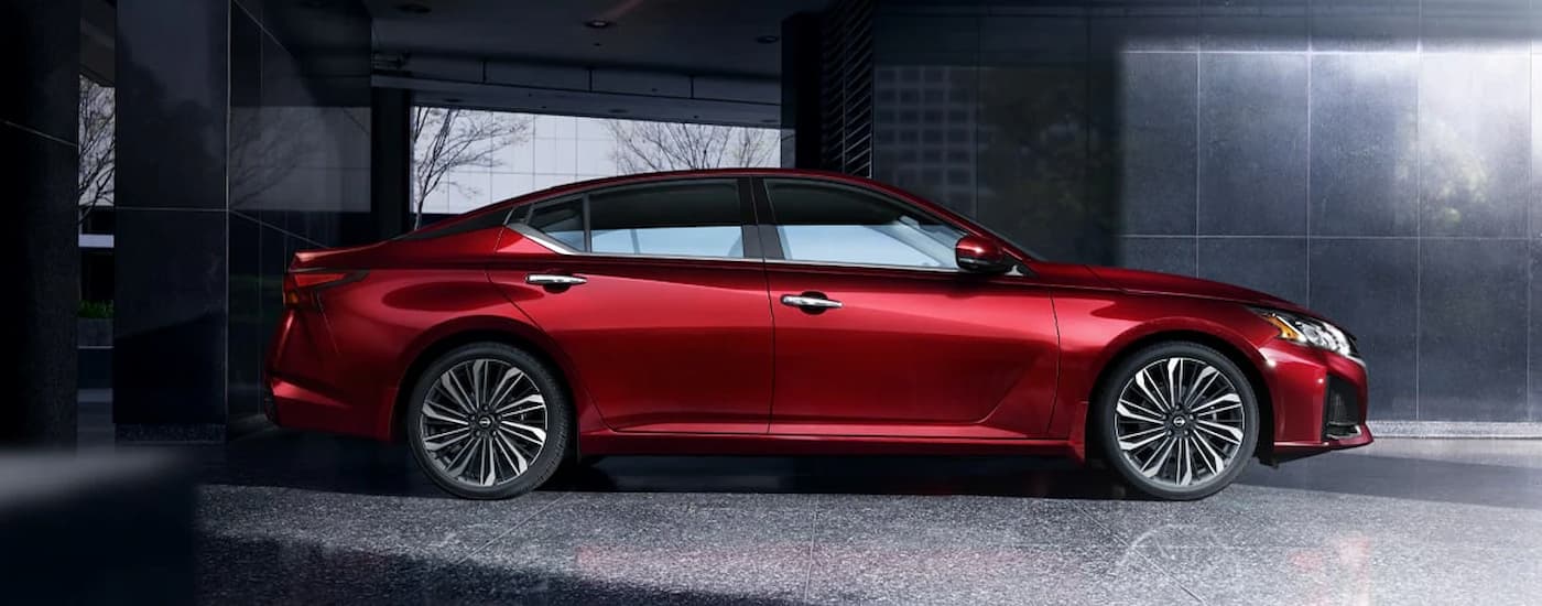 A red 2024 Nissan Altima SL is parked in a garage.