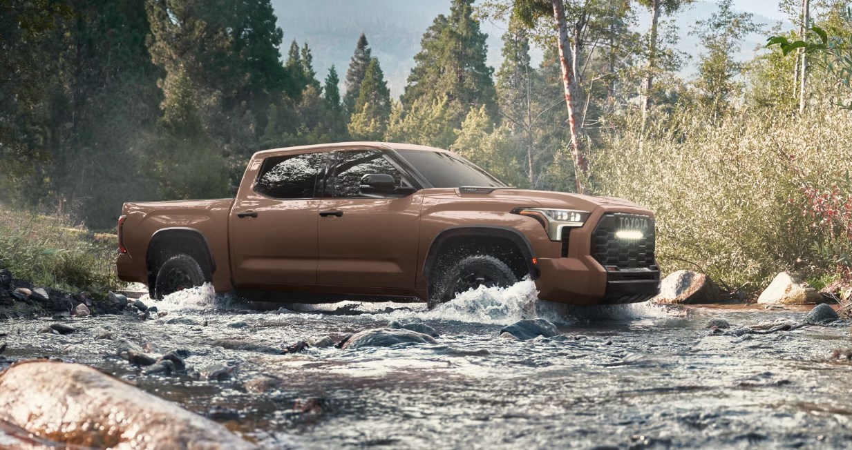 A brown 2025 Toyota Tundra fords a shallow creek
