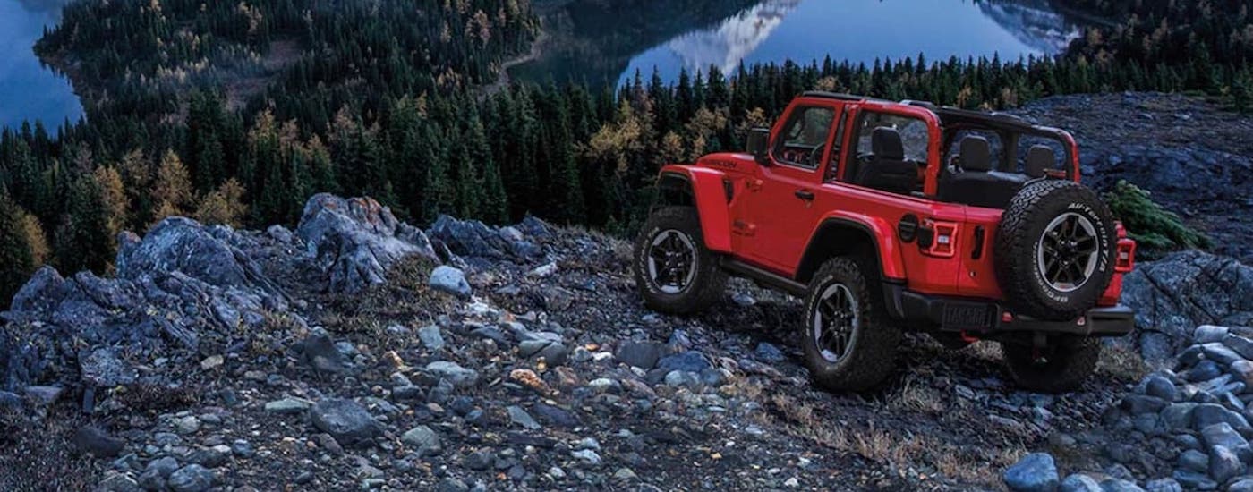 A red 2020 Jeep Wrangler for sale parked near a cliff.
