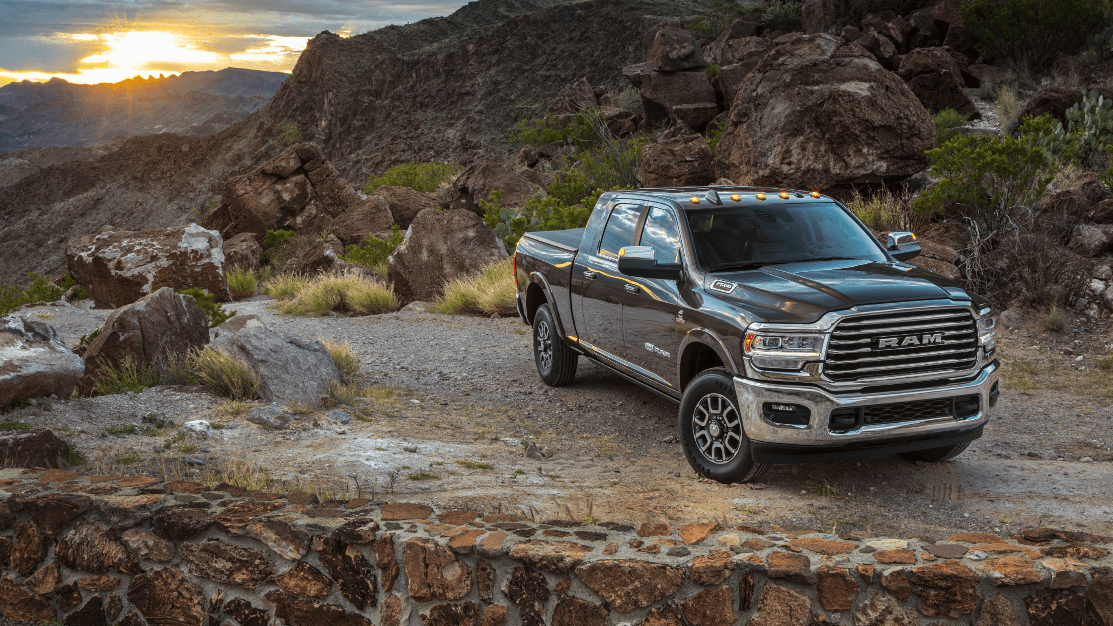 2024 Ram 2500 parked in rugged terrain at sunset.
