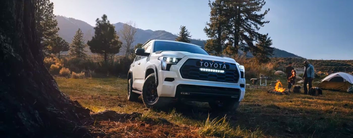 A white  2023 Toyota Sequoia TRD Pro is shown at a campsite.