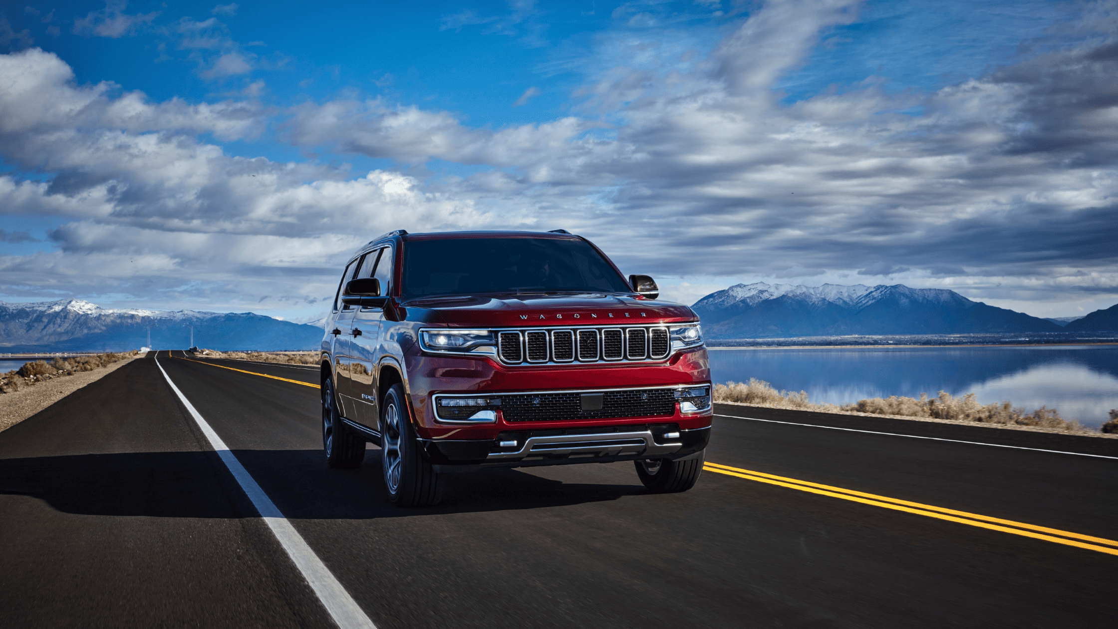 2024 Jeep&reg; Wagoneer cruising on an open highway with mountains in the background, ideal for families and adventurers in Forest City, NC.