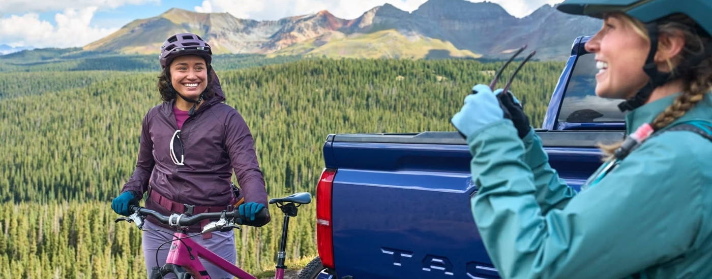 Bikers are shown near a blue 2024 Toyota Tacoma TRD Sport after leaving a Toyota dealer near Olivehurst.