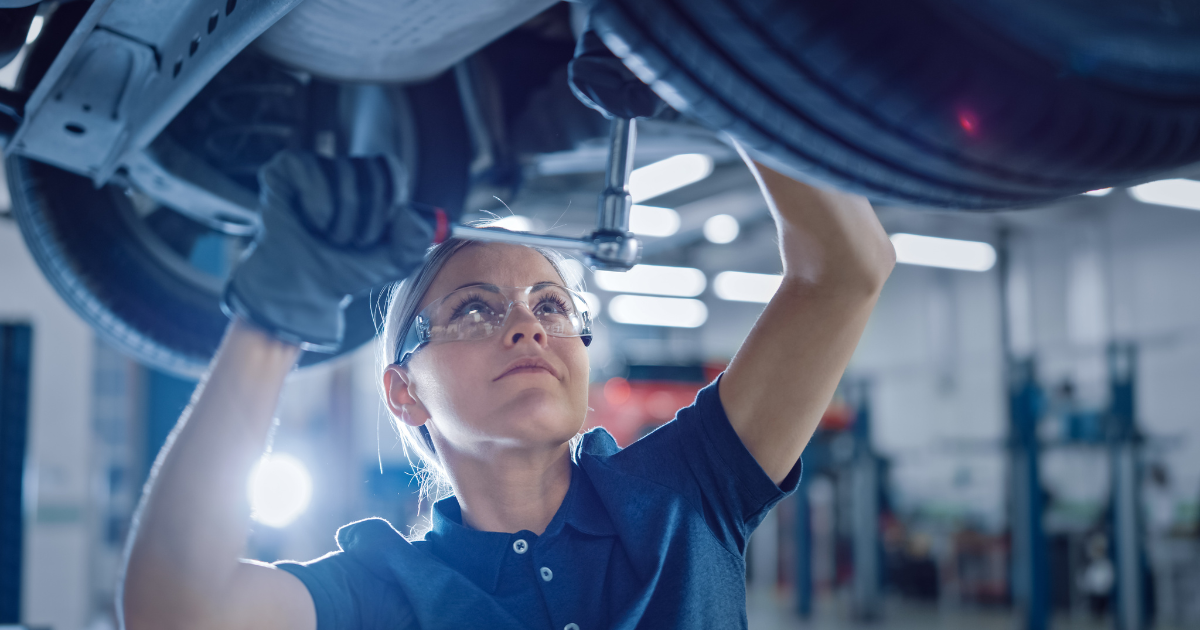 Mechanic working on the undercarriage of a vehicle