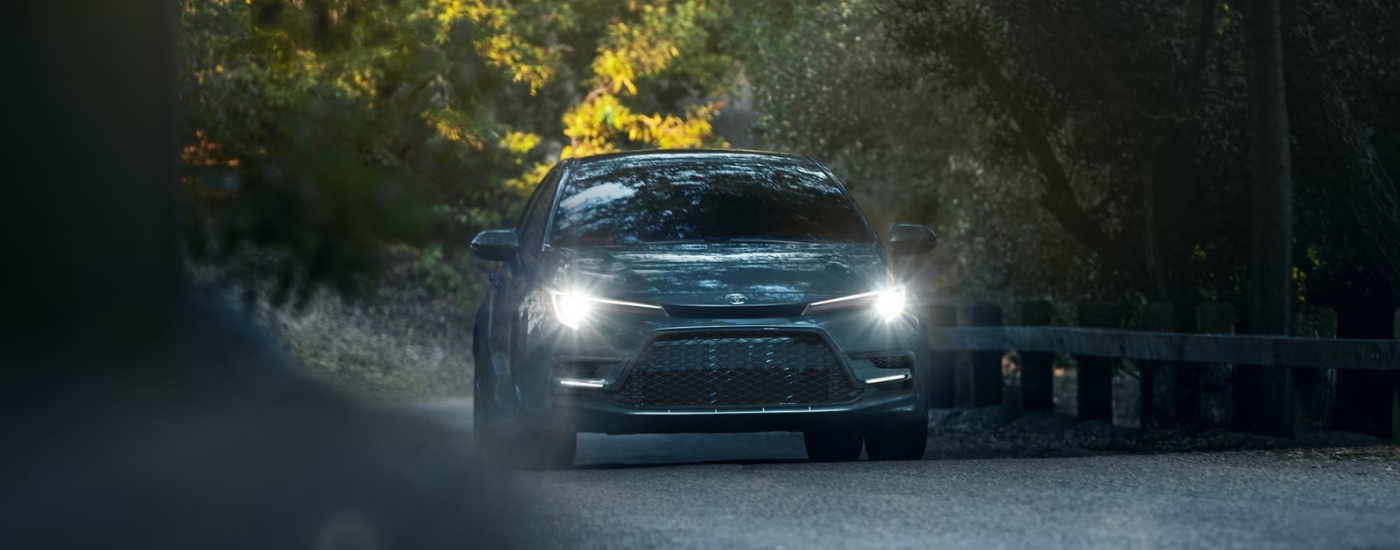 A grey 2024 Toyota Corolla driving on a back road.