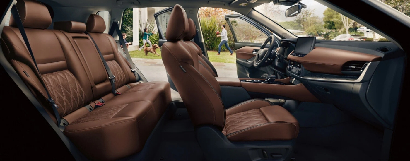 The brown interior of a 2025 Nissan Rogue is shown from the passenger side.