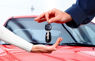 Salespeson handing customers keys to a vehicle