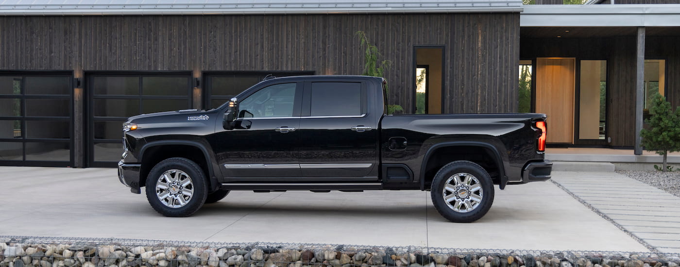 A black 2023 Chevy Silverado 2500 HD High Country is shown from the side.