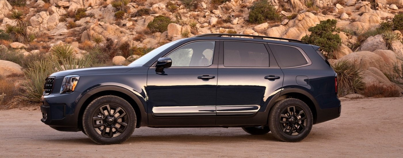 A blue 2025 Kia Telluride is shown from the side after leaving a Kia dealer.