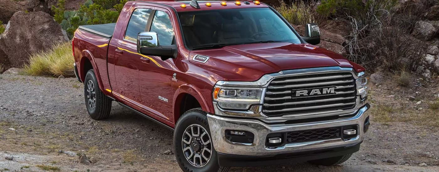 A red 2025 Ram 2500 is parked on gravel after leaving a Ram dealer.