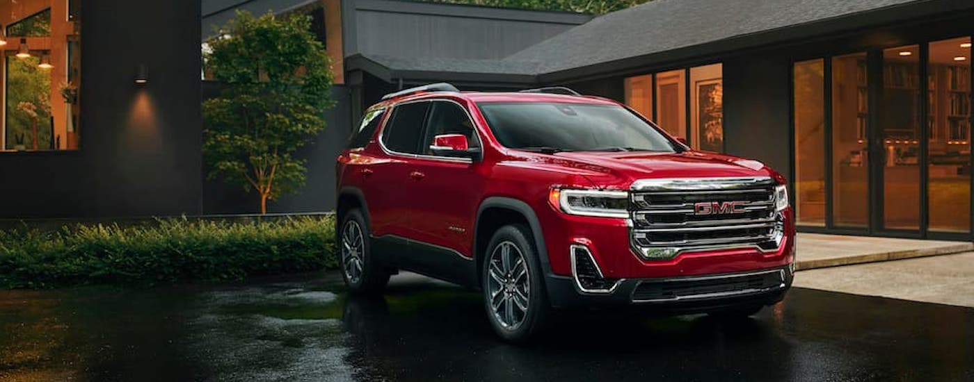 A red 2023 GMC Acadia is shown from the front at an angle.