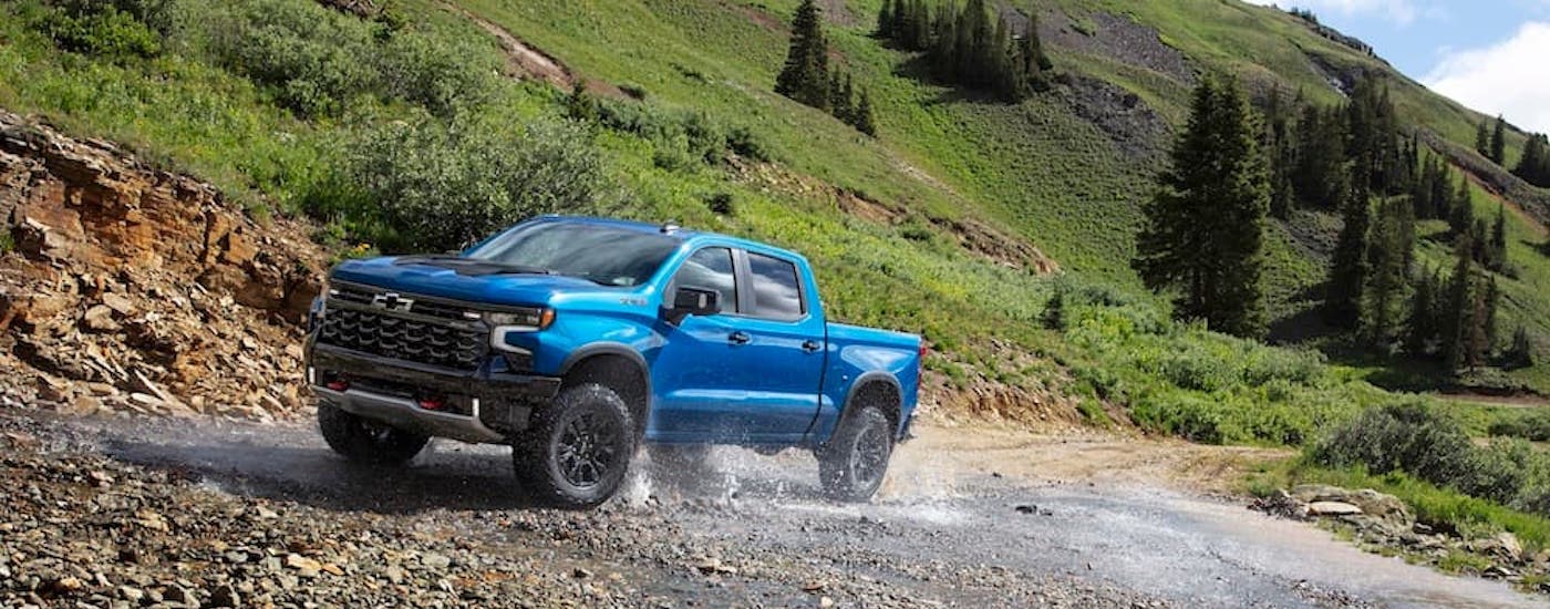 A blue 2025 Chevy Silverado 1500 ZR2 is shown from the front at an angle.