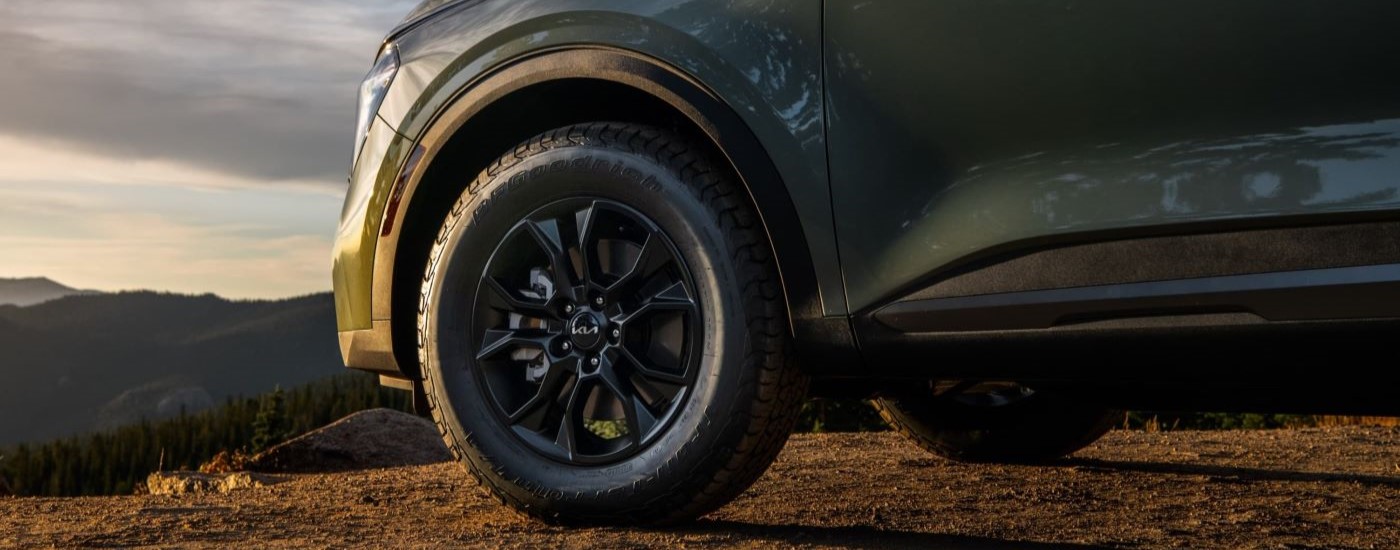 A close up of the side and tire of a green 2023 Kia Sportage.