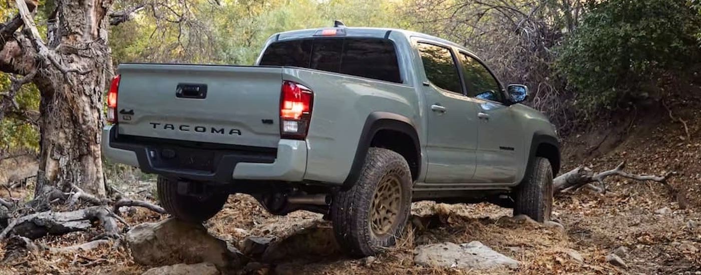 A grey 2022 Toyota Tacoma Trail is shown from the rear at an angle after leaving a dealer that has used trucks for sale near Aztec.