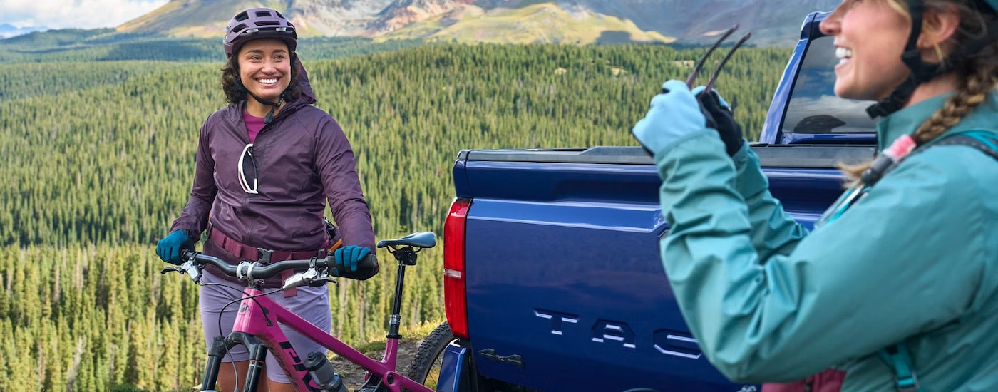 A blue 2024 Toyota Tacoma is shown from the rear in close-up.