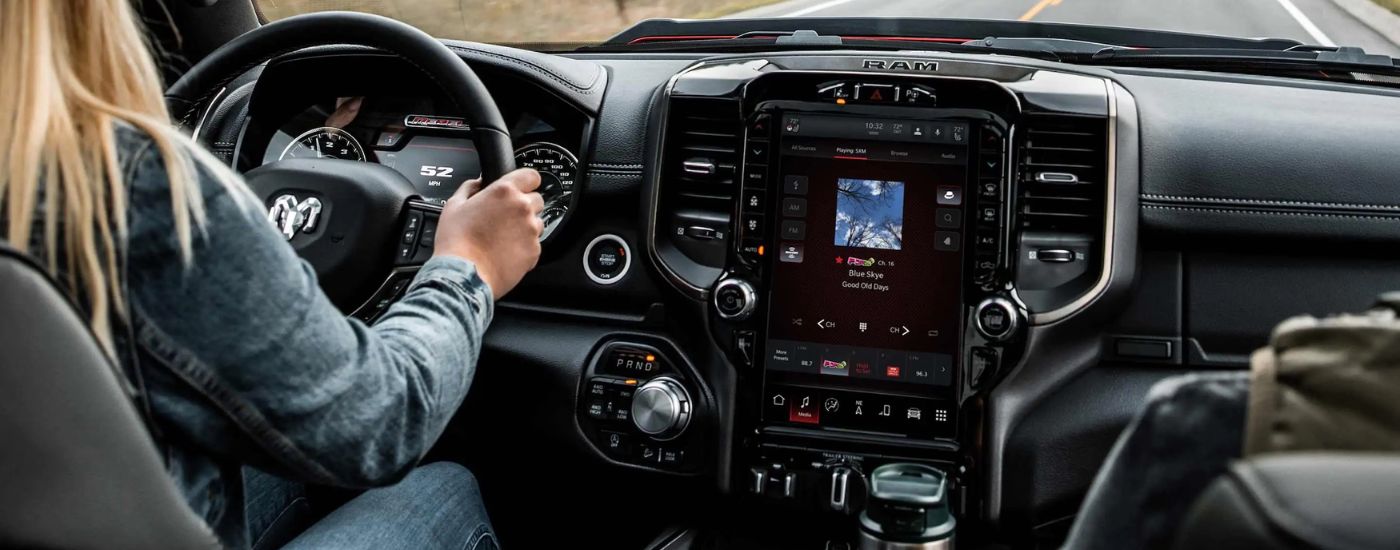 A woman is test-driving a 2022 Ram 1500 Rebel for sale near Tomball.