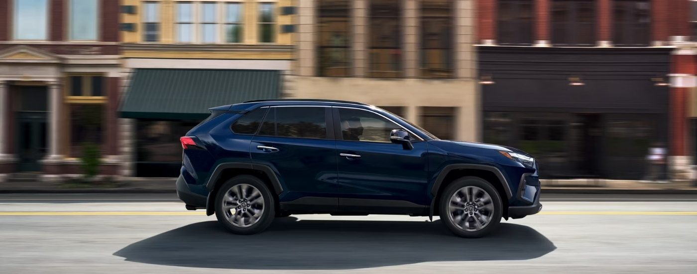 A blue 2025 Toyota RAV4 is shown from the side.