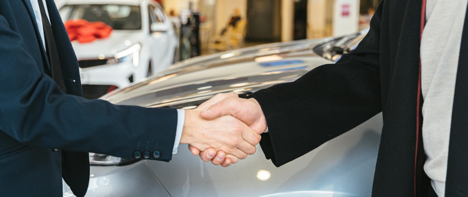 People Shaking Hands in Car Dealership