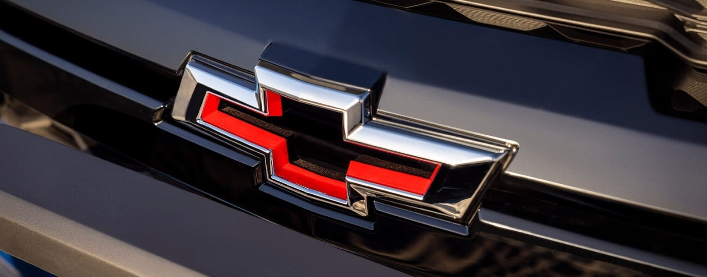 A close up of the bowtie badge on a blue 2024 Chevy Colorado for sale.