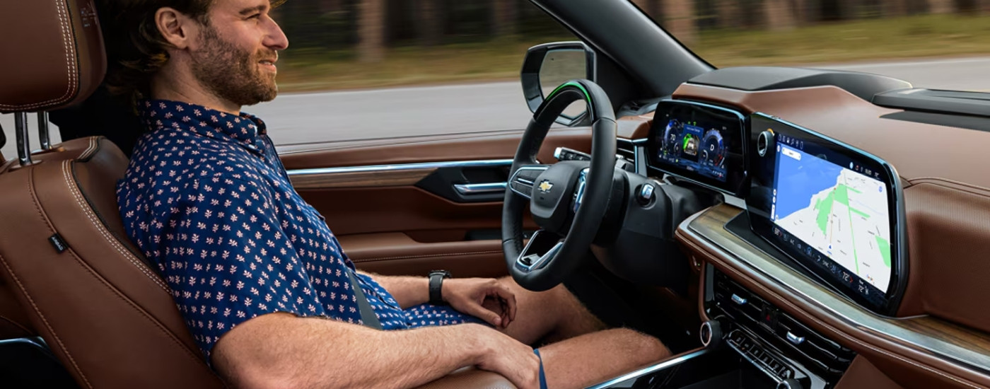 A man is driving in a 2025 Chevy Tahoe while using the Super Cruise feature.