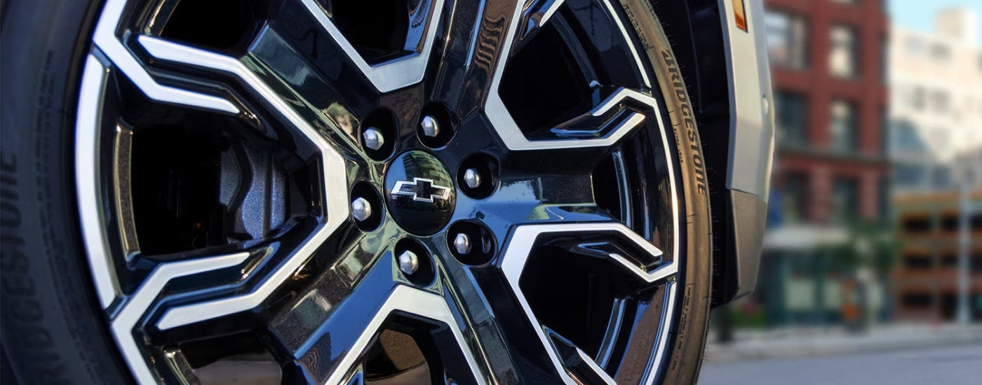 A close up of the rim and tire on a black 2025 Chevy Tahoe RST.