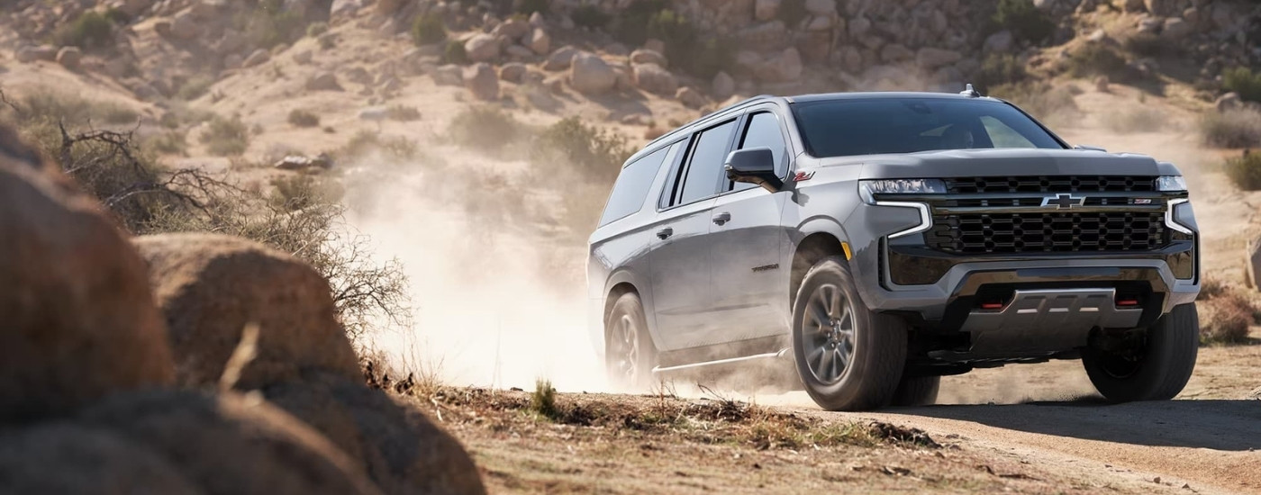 A grey 2024 Chevy Suburban Z71 is shown off-road.