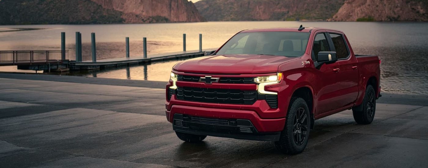 A red 2024 Chevy Silverado 1500 for sale near Houston parked in front of a body of water.