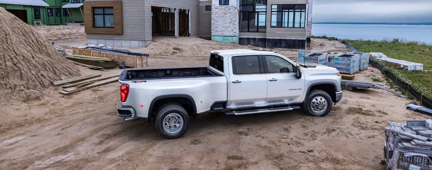 Overhead rear view of a white 2024 Chevy Silverado 3500 HD dually parked at a construction site.