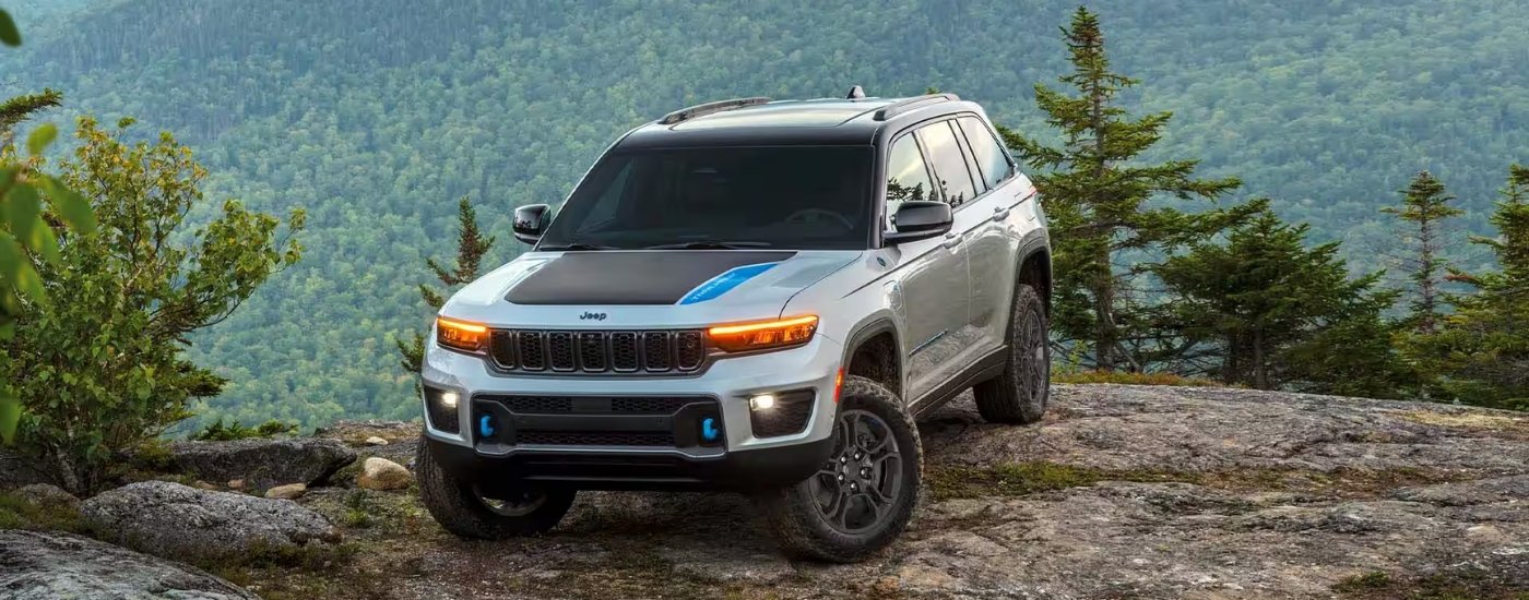 A white 2024 Jeep Grand Cherokee 4xe TrailHawk is shown from the front at an angle after leaving a dealer that has a used Jeep for sale..