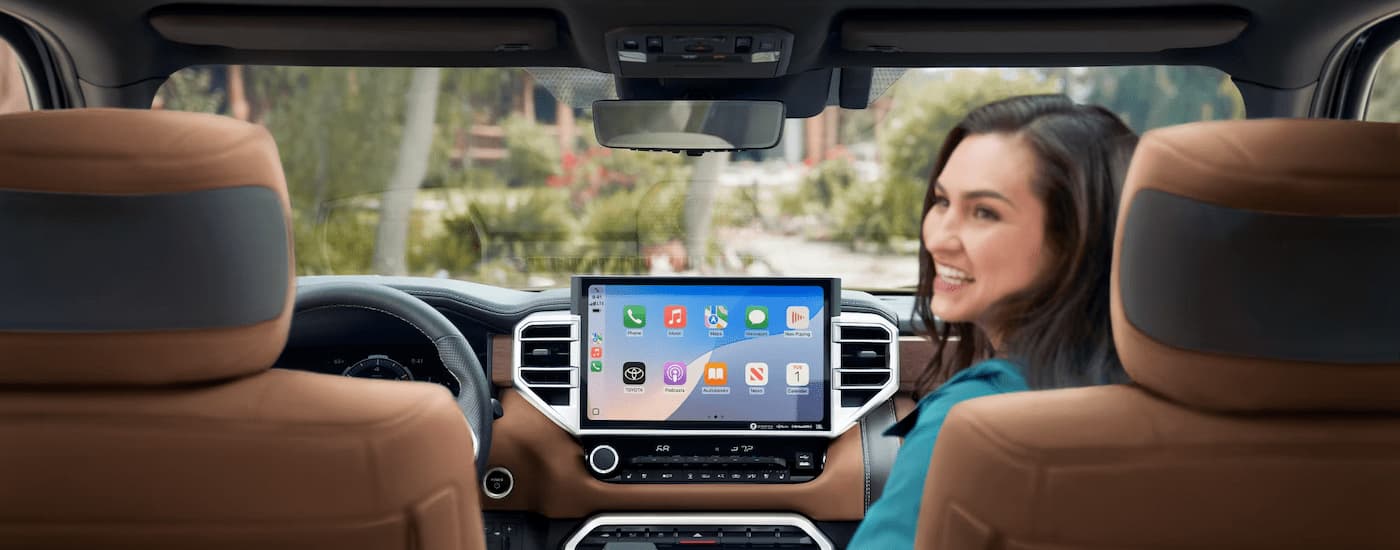 A woman is sitting in the passenger seat of a 2025 Toyota Tundra 1794 Edition CrewMax.