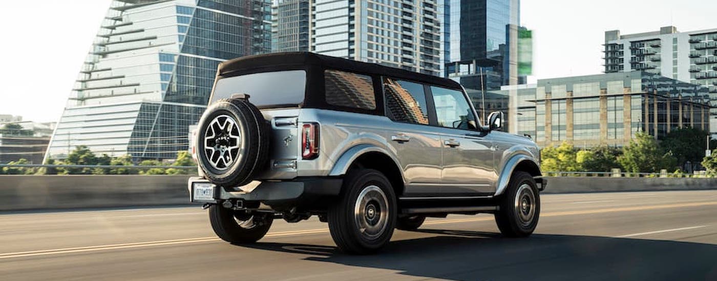 A silver 2021 Ford Bronco is shown from the rear at an angle.
