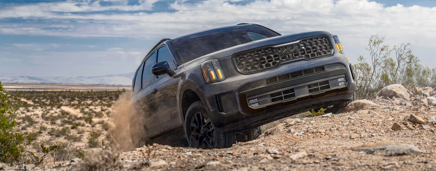 A grey 2025 Kia Telluride is off-roading on a rocky area.