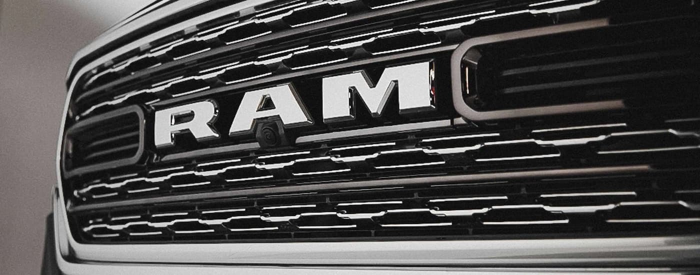 The silver grille on a 2022 Ram 1500 for sale at a truck dealer.