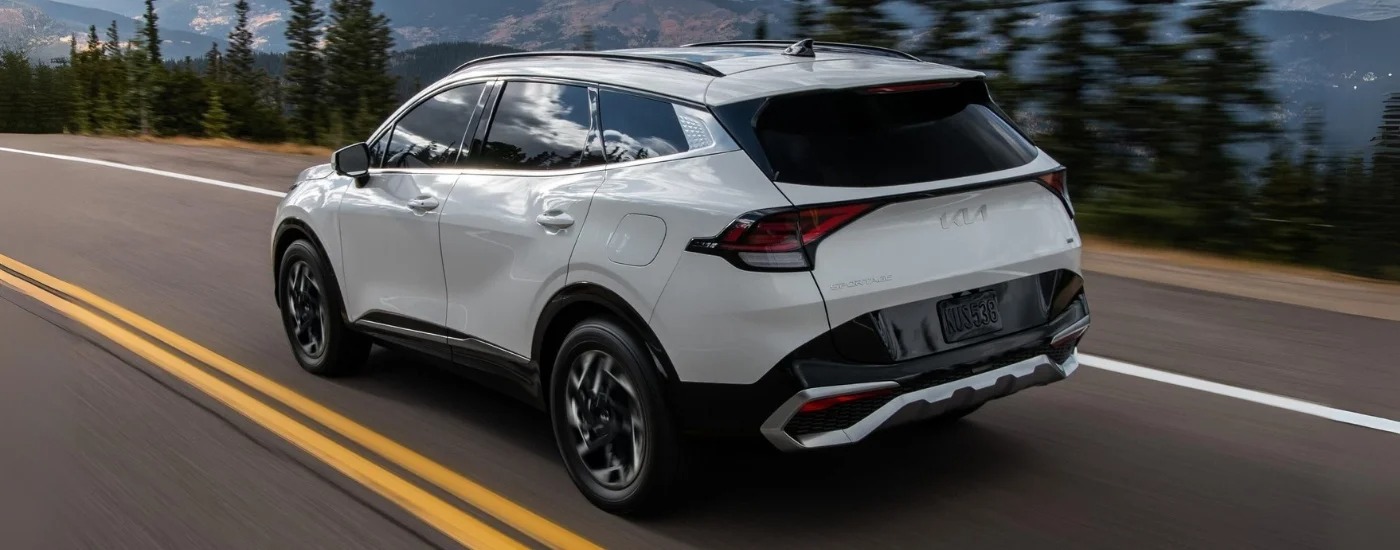 A white 2025 Kia Sportage X-Line for sale driving on an open road.