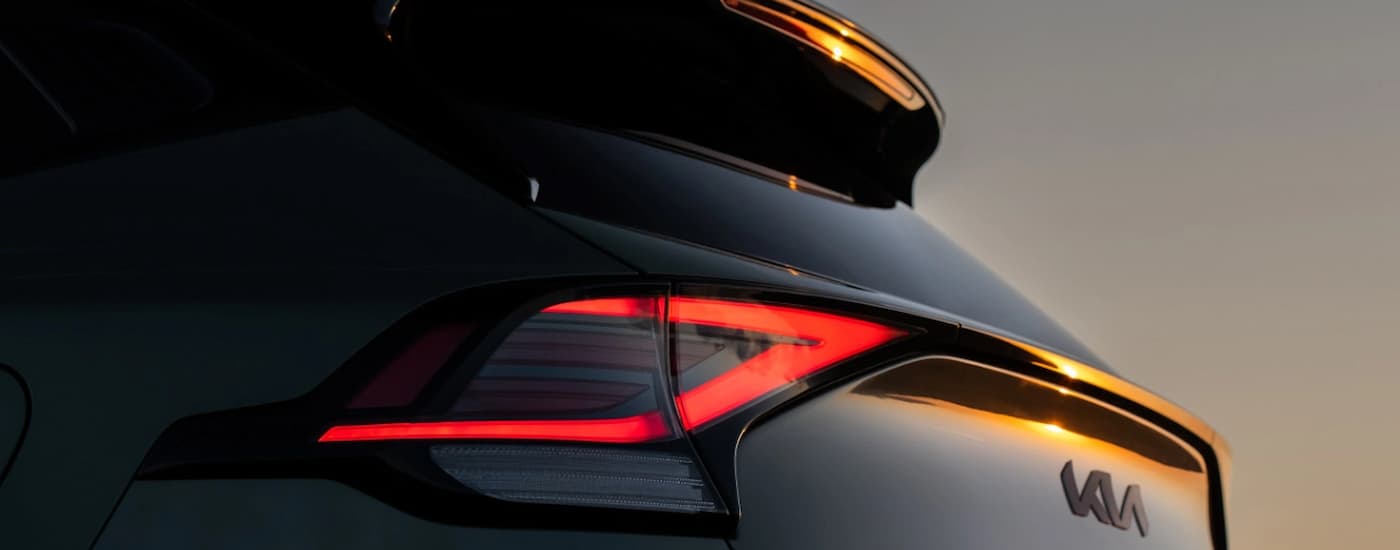 The red brake lights on a green 2025 Kia Sportage X-Pro.