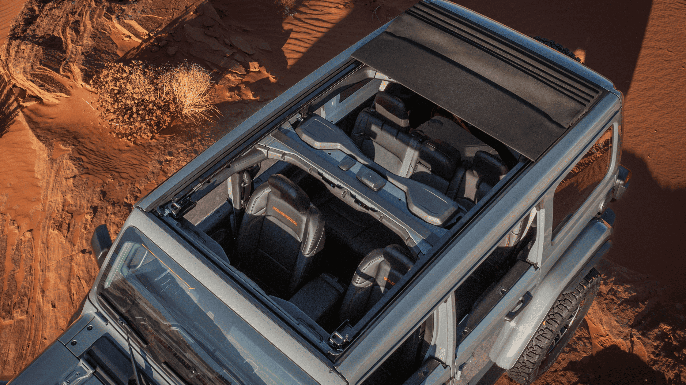 Top-down shot of the 2025 Jeep&reg; Wrangler with Sky One-Touch&reg; Power Top retracted, exposing both rows of seating.