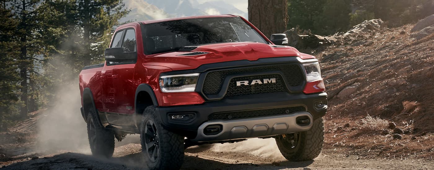 A red 2022 Ram 1500 Rebel off-roading on a dirt trail.