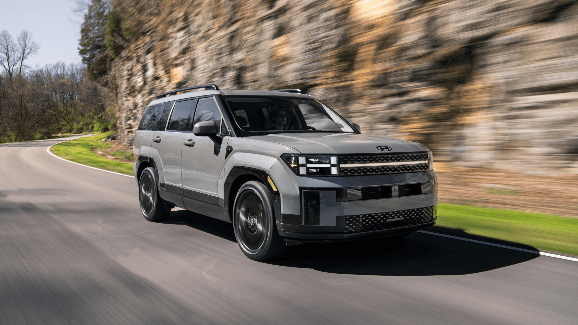 Front view of 2025 Hyundai Santa Fe driving on a curve, showcasing its bold new boxy design
