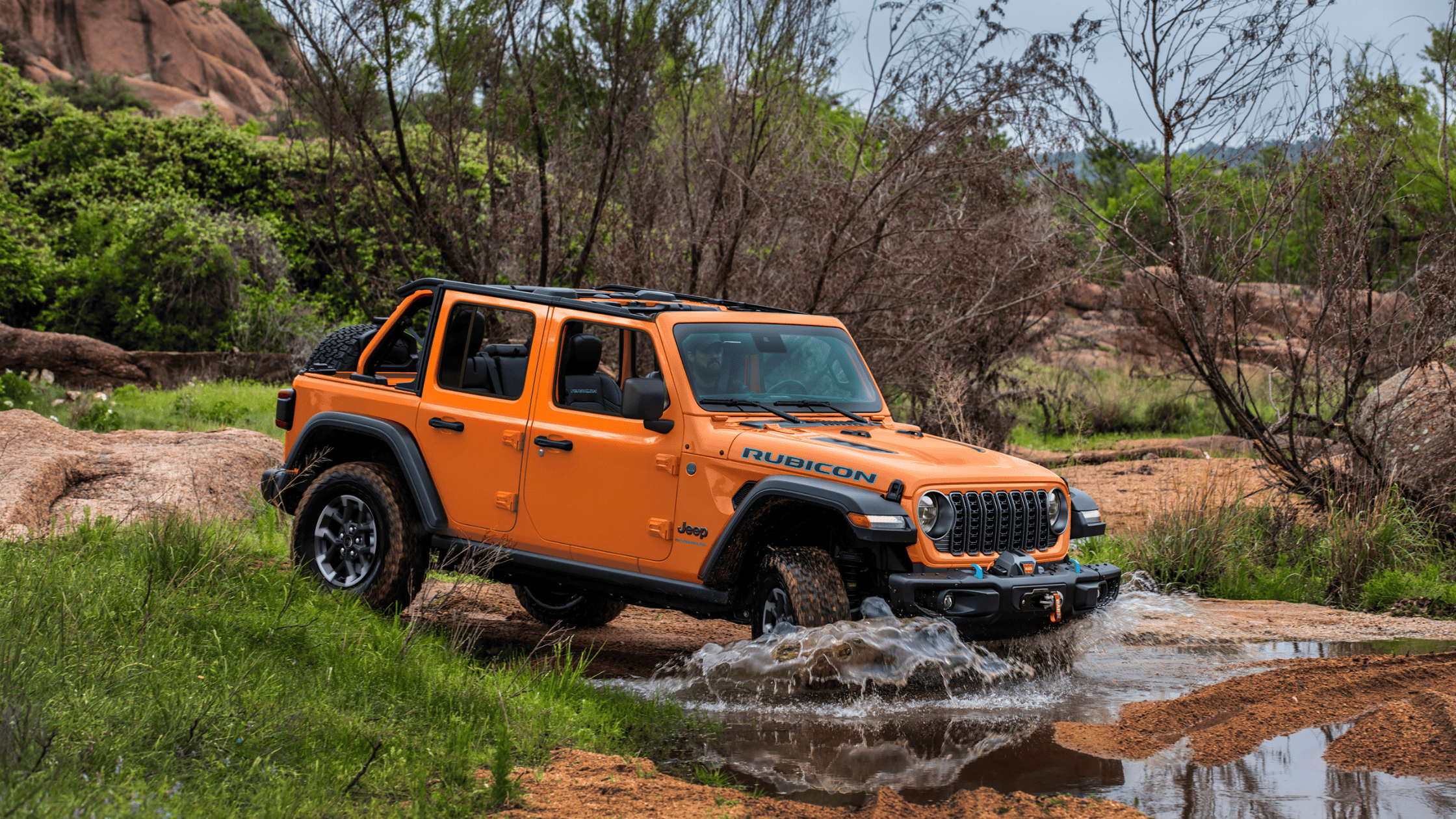 2025 Jeep&reg; Wrangler driving through water and rugged terrain