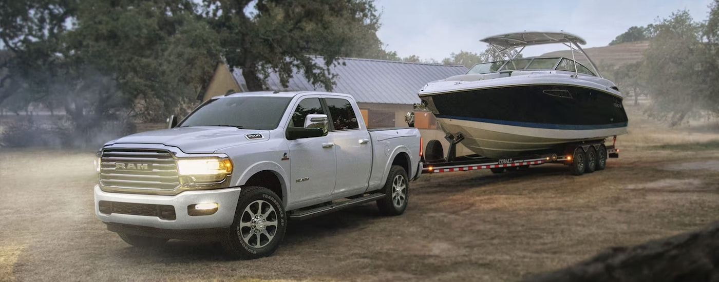 A white 2024 Ram 2500 towing a boat.