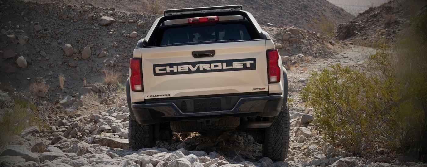 A tan 2023 Chevy Colorado ZR2 Desert Boss is driving off-road.