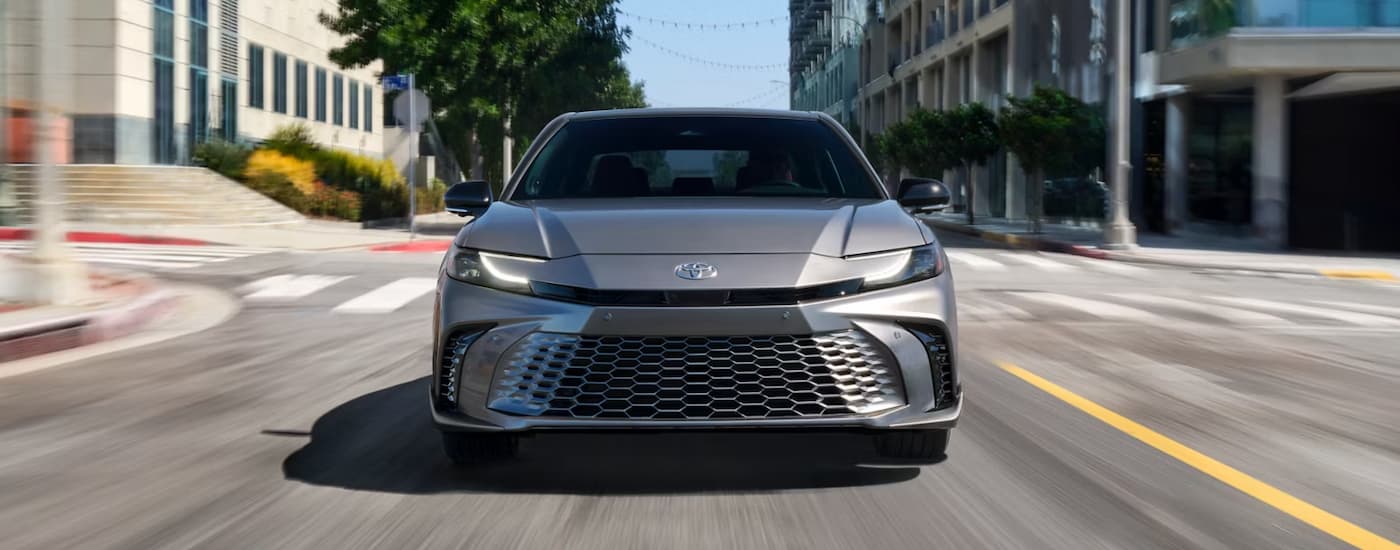 A grey 2025 Toyota Camry leaving a Toyota dealer near Seguin.